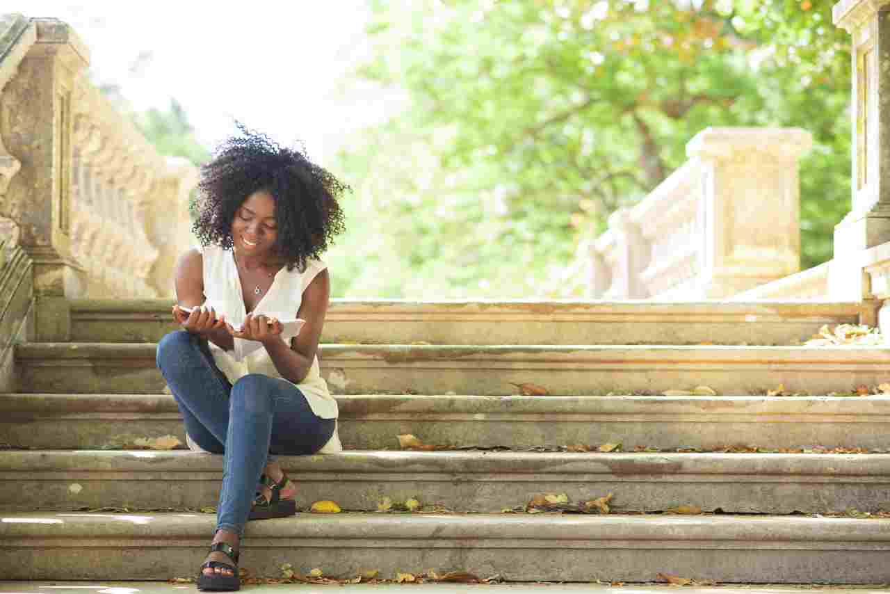 blog cover your personal story image of a woman reading on steps