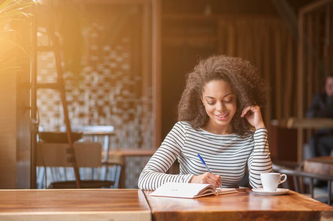 woman sitting at table getting started writing her blook